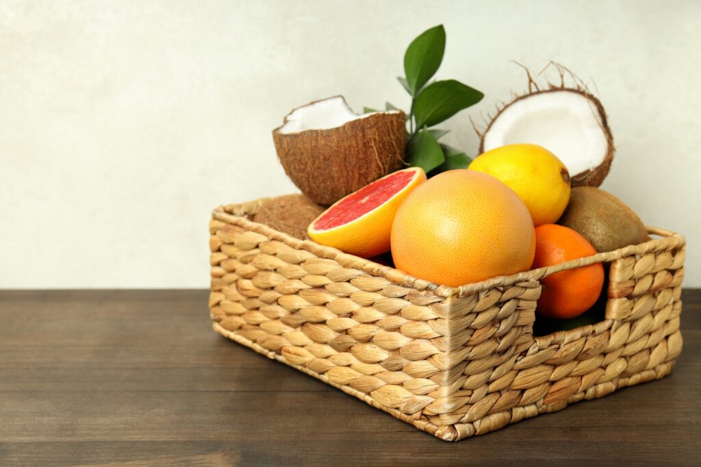 Basket with exotic fruits on wooden table